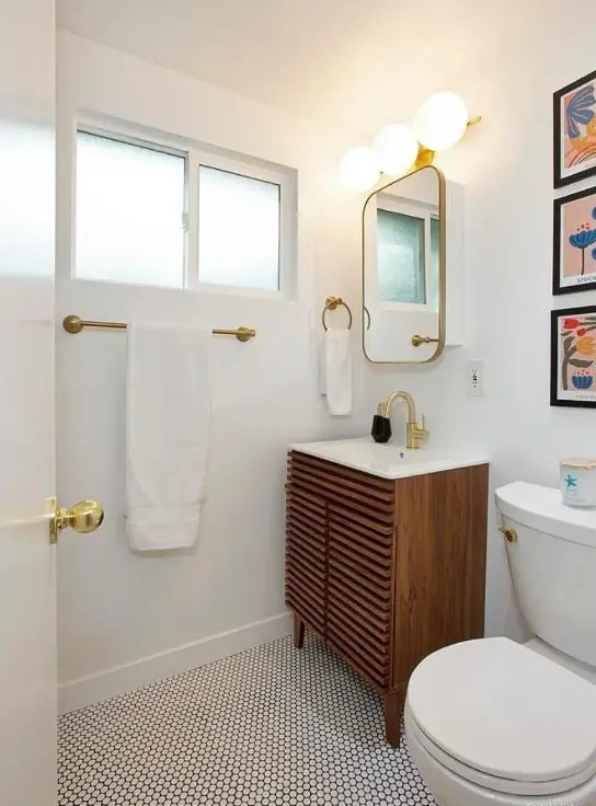 Bath with brass fixtures, arched mirror, and clerestory windows