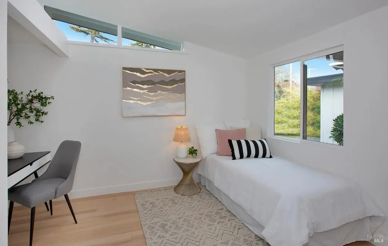 Bedroom with clerestory windows, desk, and garden views