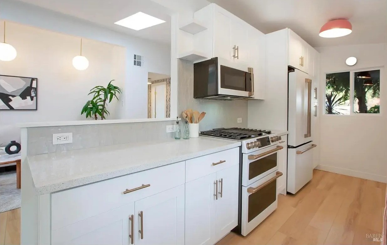 Kitchen with breakfast bar, gas range, and mid-century lighting