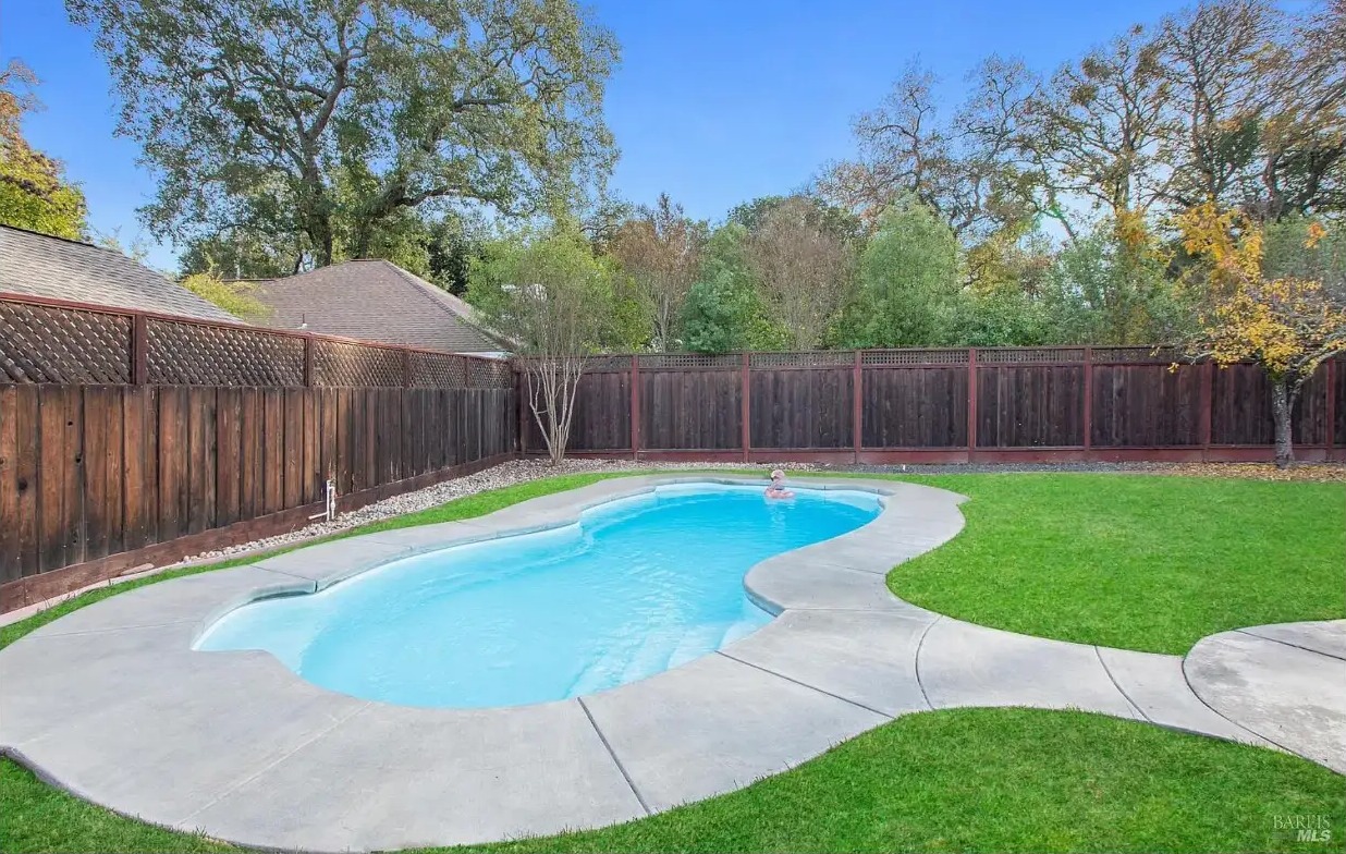 The swimming pool at 970 Glenwood Drive with solar panels visible on the main house roof