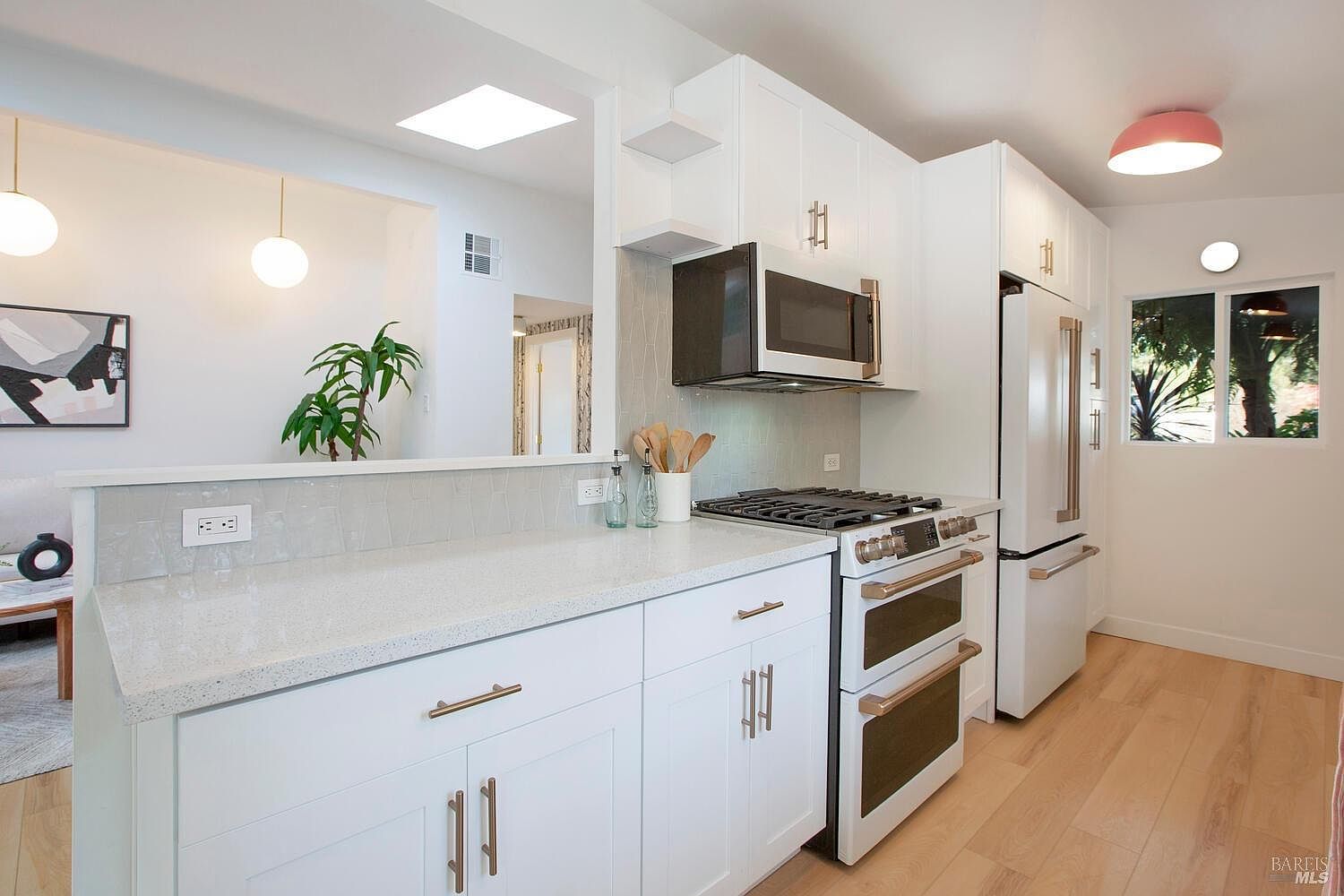 Remodeled kitchen with white cabinetry and stainless appliances